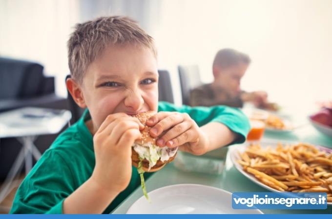 bambino che mangia voracemente del cibo non sano